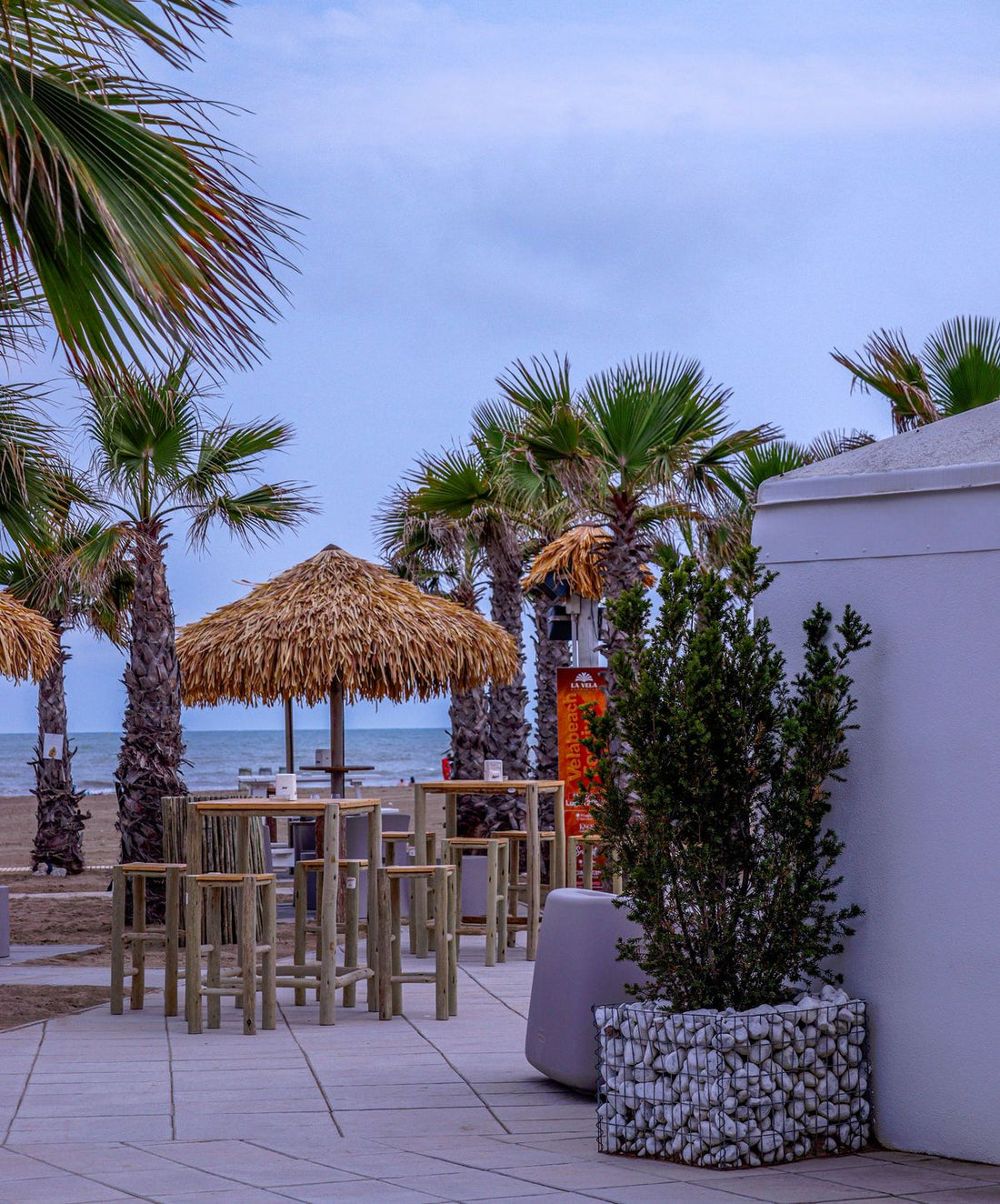 Beachfront tiki bar with palm trees and wooden high-top tables in South Florida