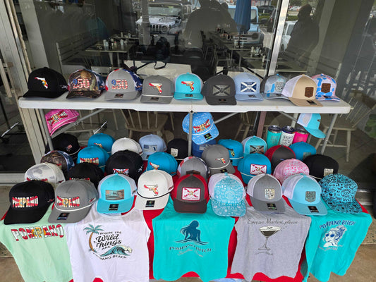 True Local popup setup at Vega Lounge Pompano Beach with trucker hats tees and tumblers on display