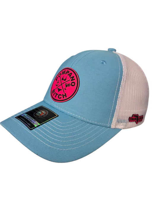 Light blue trucker hat with pink 'Pompano Bitch' patch, white mesh back, and True Local logo for Florida pride apparel.