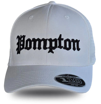 White Pompton trucker hat with black gothic lettering, mesh back, and Flexfit 110 label