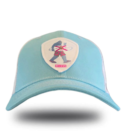 Light blue cap with Bigfoot holding surfboard, Florida flag, and 'BELIEVE' patch — local Florida apparel