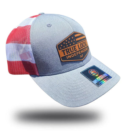 Gray trucker hat with red and white striped mesh back, featuring 'True Local Independent AF' patch and holographic tag.
